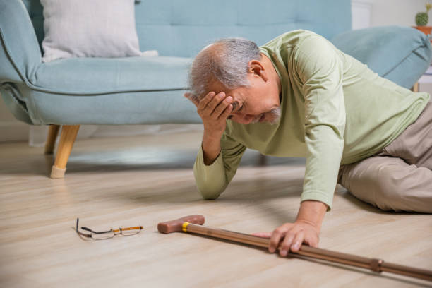 istock Asian senior man falling down lying on floor at home alone with wooden walking stick 2045081504