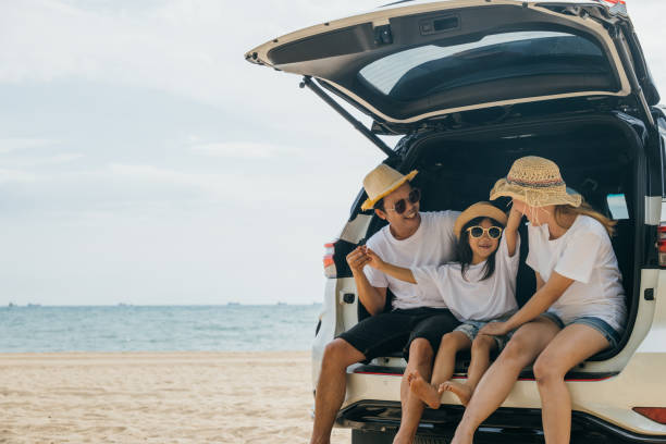 istock People enjoying road trip sitting down on back their car 2045081535