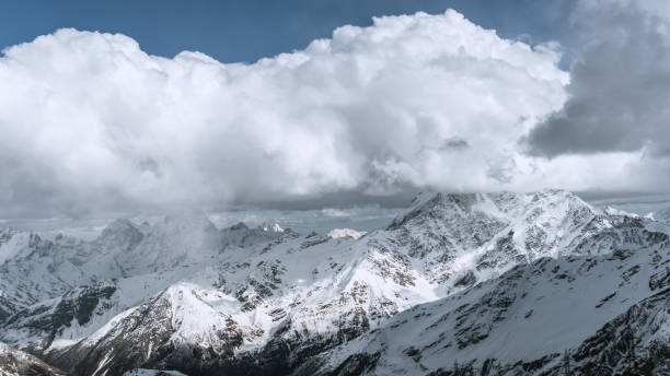 istock Alpine landscape with peaks covered with snow and clouds 2045092889