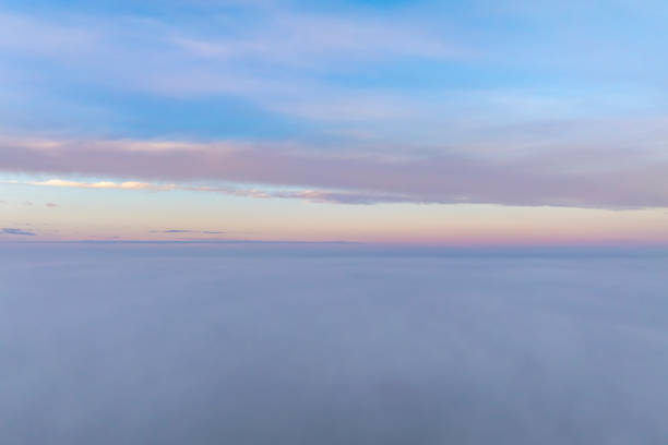 Beautiful sky above the low clouds with sunlight over the fluffy clouds. Flying Drone view.