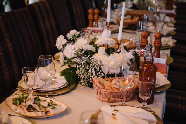 nourriture et boissons sur la table à manger. servir, dresser la table dans le hall.  assiette et verre, décor riche et luxueux. mise en place du mariage, réception à table dans un restaurant. anniversaire, baptême, événement. - absence arrangement celebration celebration event photos et images de collection