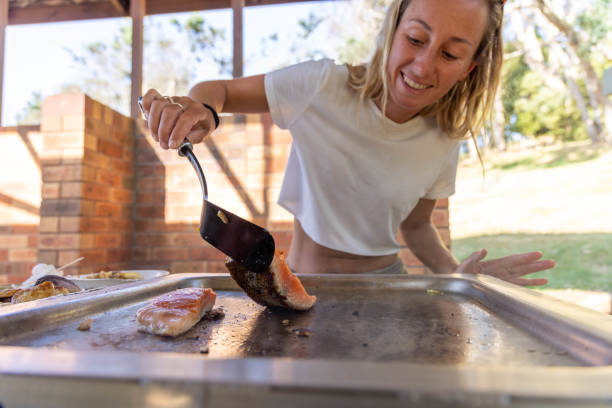 istock Grill & Thrill: Young Woman's Joyful Outdoor BBQ Adventure 2045165650