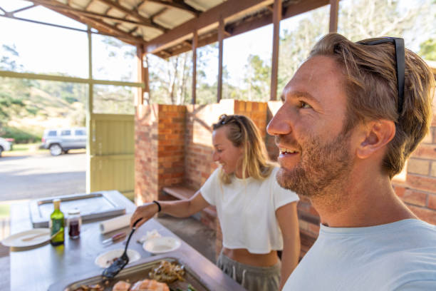 istock Culinary Bliss: Young Couple's Joyful BBQ Experience with Her at the Helm 2045165702
