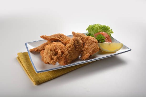 istock deep fried crispy golden chicken wings with tomato green salad in plate on white table western cafe snack cuisine restaurant halal fast food appetiser menu 2045174174