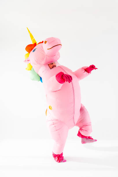 istock Unicorn in rainbow costume dancing on white surface at studio 2045185862