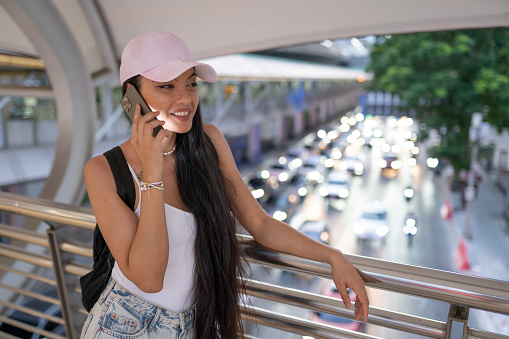 Asian girl in Bangkok, talking on a smartphone