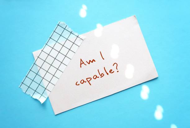 istock Blue background with handwritten text note AM I CAPABLE? - SELF-DOUBT concept, lack of confidence mindset- fear of failure, imposter syndrome, need external validation or constant reassurance 2045199755