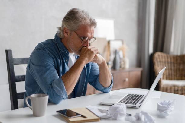 istock Frustrated middle-aged man massaging his nose and keeping eyes closed while sitting at his working place in office 2045223618