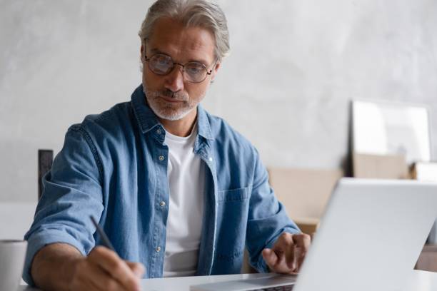 istock Middle-aged man working from home-office on laptop. 2045223629