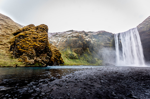 A beautiful waterfall with moss-covered cliffs. Iceland