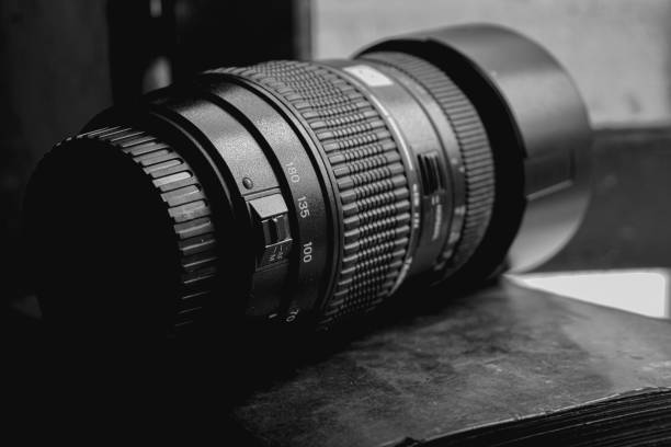 a 70-300 telephoto lens for a DSLR camera sits in the open window frame