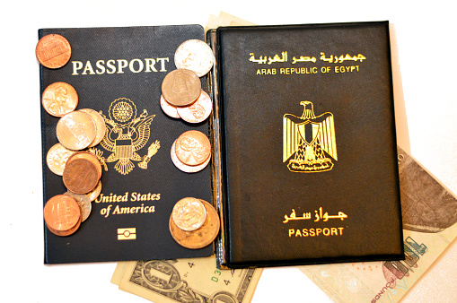 Egyptian passport, Egypt's money banknotes pounds, American passport, USD dollars and coins change, United States of America Traveler ID and Arab Republic of Egypt, travel tourism concept, selective focus