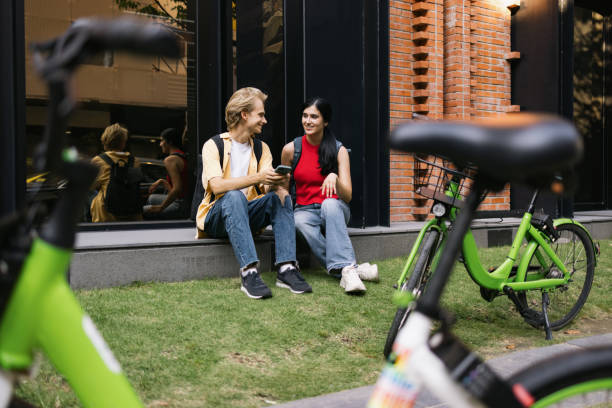 istock Happy college couple talking while using cell phone on the street. 2045251280