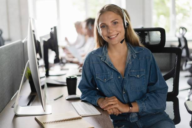 Young friendly operator woman agent with headsets working in a call center.