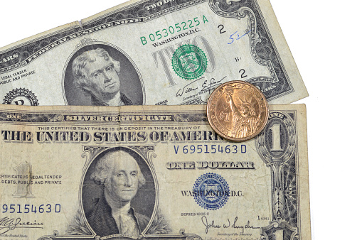 vintage retro old American money of one American dollar series 1935 banknote with George Washington, 2 dollars 1976 Thomas Jefferson, commemorative 1 dollar coin of Martin Van Buren, liberty statue, selective focus