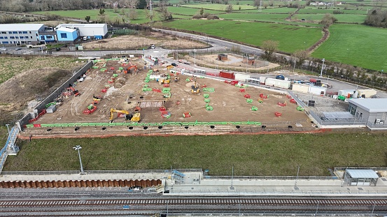 Aerial view of construction site beside railway tracks and buildings