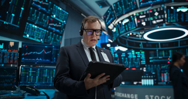 istock Stock Exchange Professional Communicating in an Open Outcry Method on a Trading Floor. Stylish Man Shouting and Using Hand Signals to Transfer Information About Buy and Sell Orders to His Broker 2045284439
