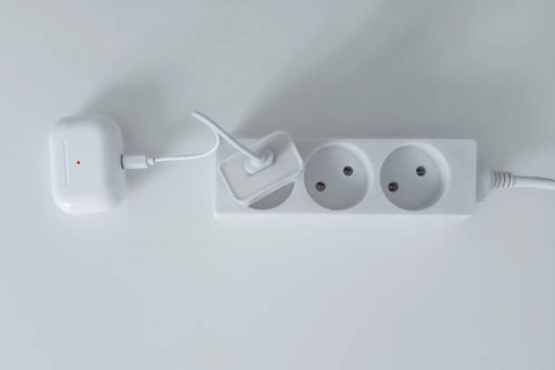 istock Charging case for wireless headphones with USB cable plugged into an electrical outlet. 2045312937
