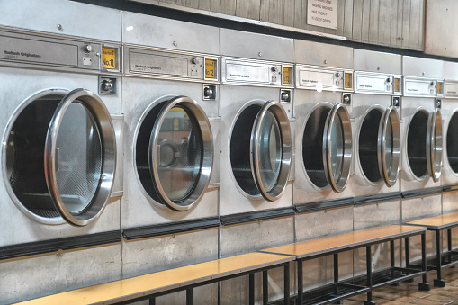 A coin wash and self-service laundry in London, equipped with washing machines, tumble dryers, and coin-op machines, offers a convenient and efficient space for laundry needs. Additionally, the establishment in the photo provides dry cleaning services.