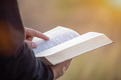 young man pointing to a bible topic and read the Bible on Sundays to receive the blessings of God.