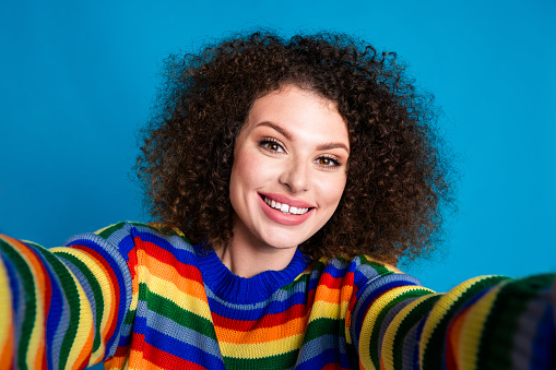 Photo portrait of pretty young girl selfie photo cheerful smile wear trendy rainbow print outfit isolated on blue color background.
