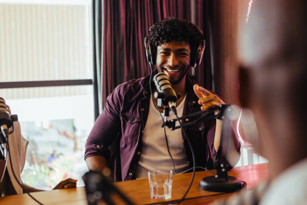 istock Cheerful man hosting podcast show with professional microphone in studio 2045381804