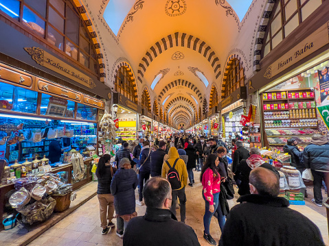 Istanbul, Turkey - 6 March 2022: People walk in the Spice Bazaar (Turkish: Mısır Çarşısı, meaning 'Egyptian Bazaar'), one of the largest bazaars in the city.