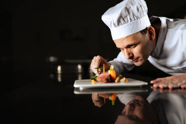 Chef decorating a plate Chef decorating a plate and putting the ultimate touches chef stock pictures, royalty-free photos & images