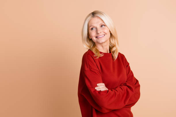 istock Photo of dreamy excited lady dressed red pullover arms folded looking back empty space isolated beige color background 2045398955
