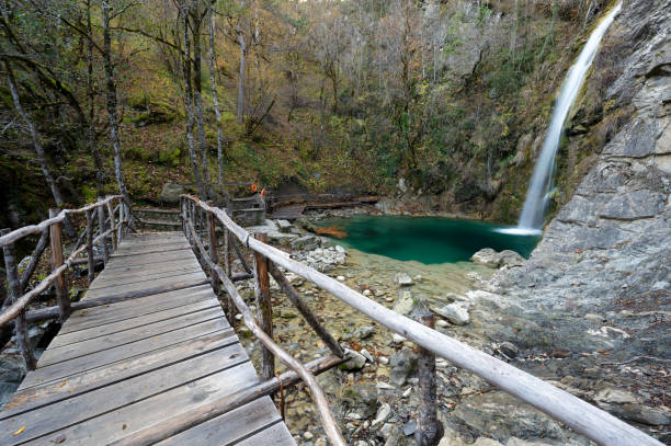 Waterfall in Greece View of the Balta di Stringa waterfall with wooden bridge near the village of Iliochori at the area of Zagori in Epirus, Greece zagori stock pictures, royalty-free photos & images