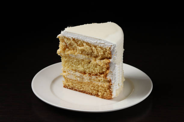 istock A piece of white cake with marzipan under dark lighting. Close-up 2045425886