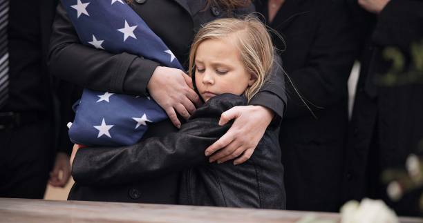 sad, hug and a child at a funeral or graveyard for a ceremony or death with family. depression, young and a girl kid with a person for comfort at a cemetery for mourning, grief together or loss - child grief mourner disappointment ストックフォトと画像