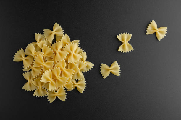 istock Raw pasta farfalle on black background. 2045463569