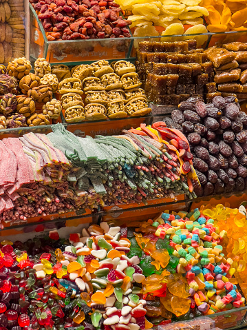 Many jelly sweets, dried fruits and nuts on a sales counter at the spice market in Istanbul, Turkey. Huge variety of traditional eastern sweets at the Grand Bazaar. Colourful food background with copy space.