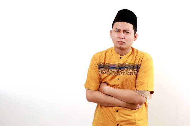 Headshot of a man dressed in a traditional thawb and headscarf, gazing slightly downward at the camera.