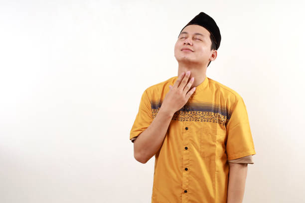 Young asian muslim man feeling relieved while touching his throat