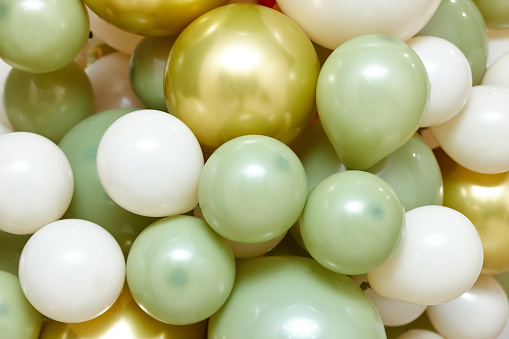 Many white green and gold balloons as background