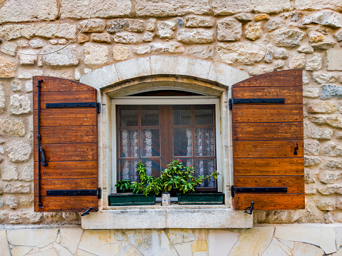 Weathered facade of a mountain hut with summer mountain reflections