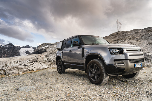 Passo dello Stelvio, Italy - August 27, 2021 : The New Land Rover Defender against the alps at Passo dello Stelvio close to Bormio