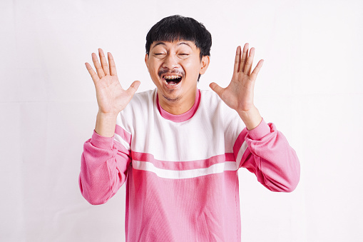 Young man standing over white background waiving saying hello happy and smiling, friendly welcome gesture. Hi five and sports concept