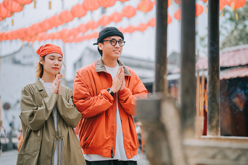 Asian Chinese couple tourist praying in front of Chinese temple in Penang island during chinese new year chap goh meh