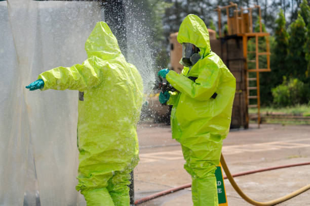 undergo decontamination in an inflatable shower tent. dedicated professionals in protective workwear is seen walking through an inflatable disinfectant shower tent, diligently cleaning chemical residue from their protective suits. - radiation protection suit toxic waste protective suit cleaning - fotografias e filmes do acervo