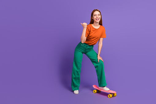 Full length photo of cheerful good mood girl demonstrating empty space seasonal offer sport store isolated on violet color background.