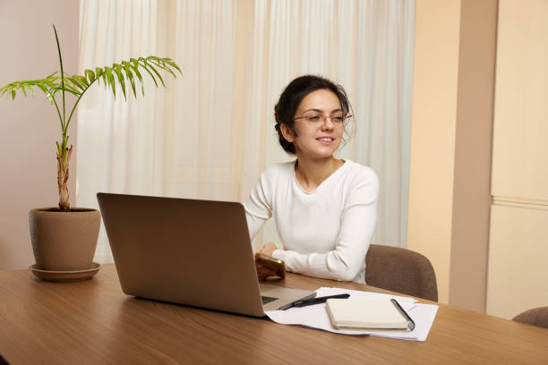 istock pretty woman in glasses using laptop at home 2045594145