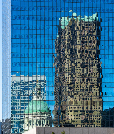 Reflections of Old Courthouse and modern office skyscraper in a mirrored building in downtown St Louis in Missouri