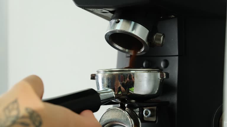 Barista grinds coffee beans using professional machine