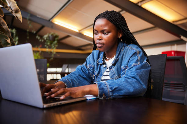 istock Young female college student working on a laptop in a school library 2045629680
