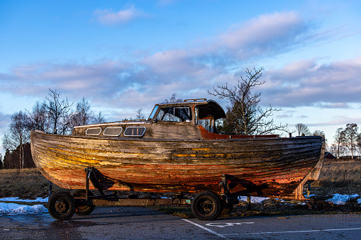 Enkoping, Sweden An old  wooden boat on a trailer sitting in a parking.