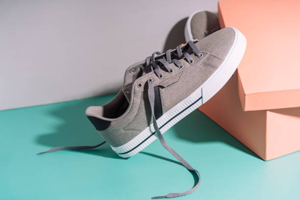 istock Fabric gray sneakers with rubber white soles in front of box 2045651938