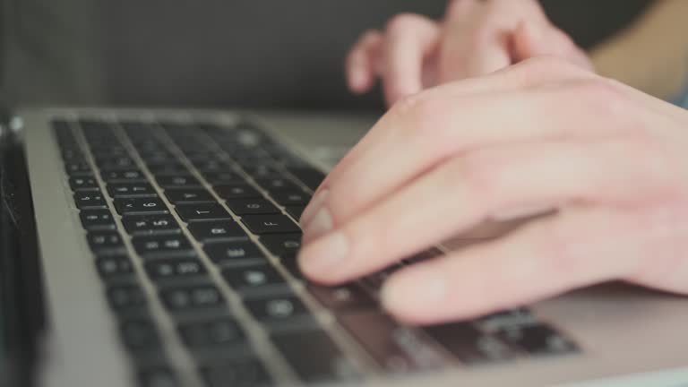 Fingers typing on laptop keyboard. Concept of work at home, women's remote work, freelance, training, chatting.